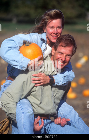 Ein Mann und eine Frau genießen Sie die sonnigen Herbsttag beim Kauf eines Kürbis in ein Bauern-Markt-Feld. Stockfoto