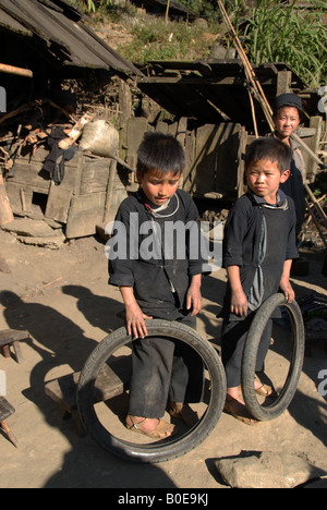 junge Burschen aus dem schwarzen Hmong-Stamm, spielen mit Fahrradräder,, Sapa, vietnam Stockfoto