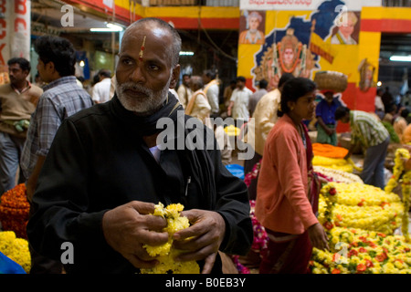 Eine Blumenverkäuferin steht in der Haupthalle der Stadtmarkt in Bangalore, Südindien. Stockfoto