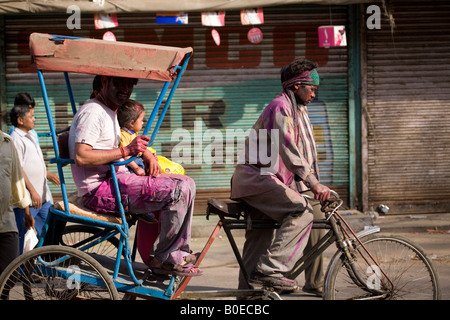 In Paharganj Markt von Neu-Delhi ist eine Fahrradrikscha radelte. Der Fahrer ist mit Pulver durch das Holi Festival gefärbt. Stockfoto