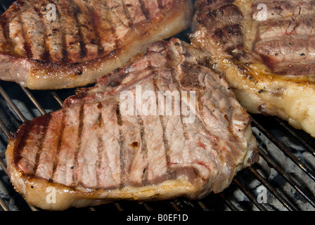 Gegrillte Steaks ruhen auf einem Barbecue Grill Waitring um bedient zu werden Stockfoto