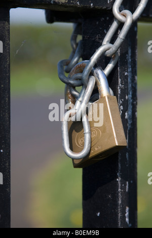 Nahaufnahme von Vorhängeschloss und Kette sichern ein schmiedeeisernes Tor Stockfoto