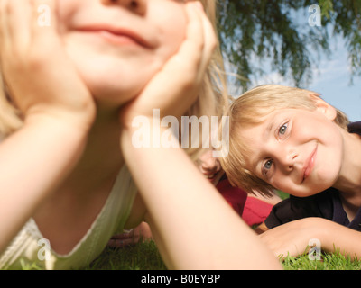 Junge Kinder liegen auf dem Rasen, Nahaufnahme Stockfoto