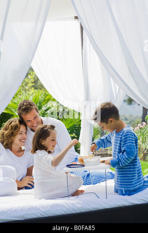 Familie frühstücken im Bett im Garten Stockfoto