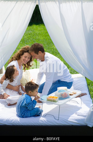 Familie frühstücken im Bett im Garten Stockfoto