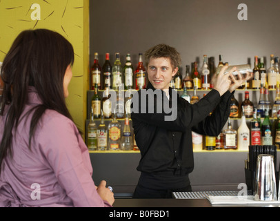 Junge Frau im Gespräch mit Barmann Stockfoto