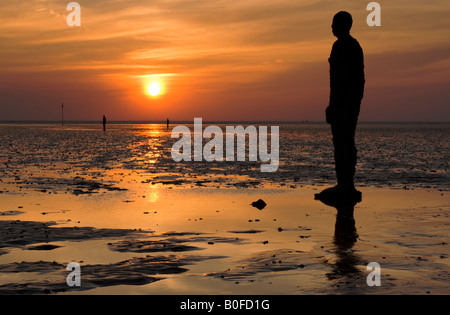 Antony Gormley's woanders Statuen bei Sonnenuntergang auf Crosby Strand, Crosby, Merseyside, England, UK Stockfoto