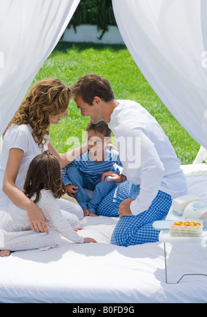 Familie frühstücken im Bett im Garten Stockfoto