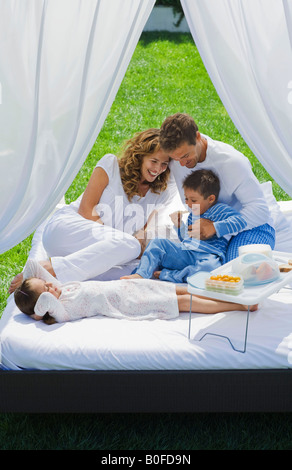 Familie frühstücken im Bett im Garten Stockfoto