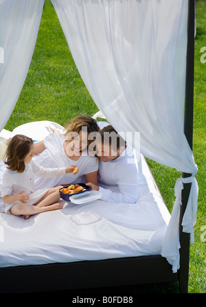 Familie frühstücken im Bett im Garten Stockfoto