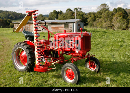 Antike 1952 International Farmall Cub Traktor mit einem Mäher Stockfoto