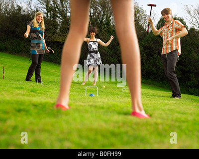 Mann und Frauen spielen Krocket im Garten Stockfoto