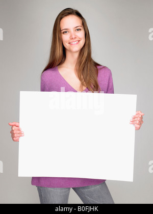 Frau, die einen Hinweis, Lächeln Stockfoto