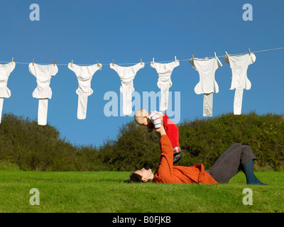 Mutter liegen auf dem Rasen hält baby Stockfoto