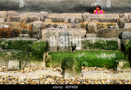 junge Frau in rosa Bikini sonnt sich unter das Meer Abwehrkräfte Southsea England uk Stockfoto