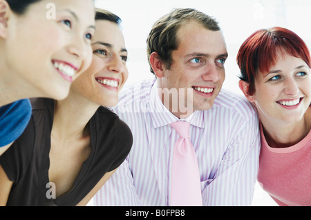 Vier glückliche Menschen, die auf der Suche hinter der Kamera Stockfoto