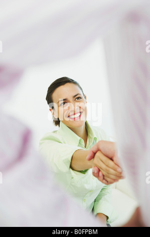 Lächelnde Frau Händeschütteln Stockfoto