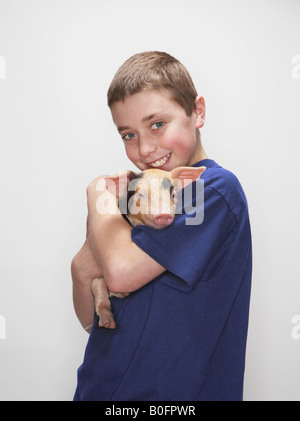 Boy Holding Ferkel Stockfoto