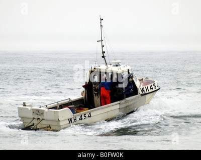 Angelboot/Fischerboot und Crew Position heraus zum Meer an einem grauen Tag Stockfoto