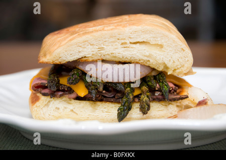 Ein heißes Sandwich mit Pastrami, gegrillter Spargel, roten Zwiebeln und Cheddar-Käse auf Asiago Käsebrot gemacht. USA. Stockfoto