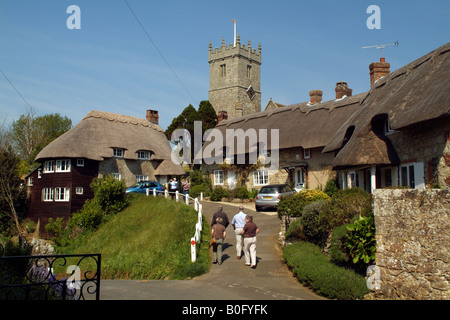 Touristen in strohgedeckten Cottages und Kirche bei Godshill Isle of Wight, England Stockfoto