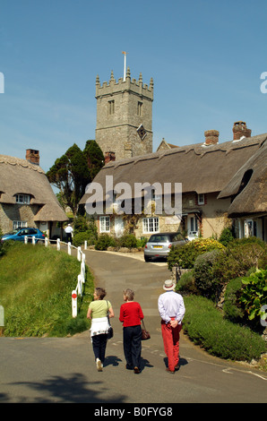 Touristen in strohgedeckten Cottages und Kirche bei Godshill Isle of Wight, England Stockfoto