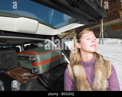 Junge Frau vor gepackten Auto Stockfoto