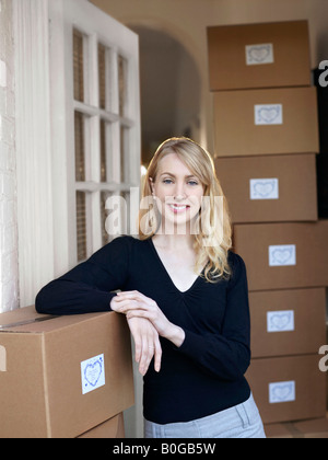 Frau, stützte sich auf Boxen in Tür Stockfoto
