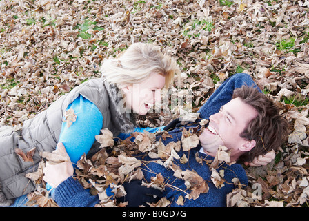 Paar, lachen, im Laub liegend Stockfoto