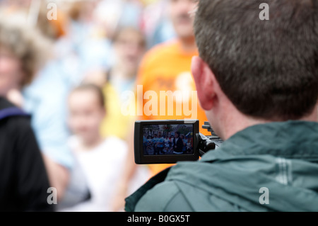 Videofilmer, die Aufnahme einer Menschenmenge Stockfoto