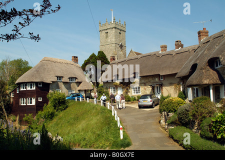 Touristen in strohgedeckten Cottages und Kirche bei Godshill Isle of Wight, England Stockfoto