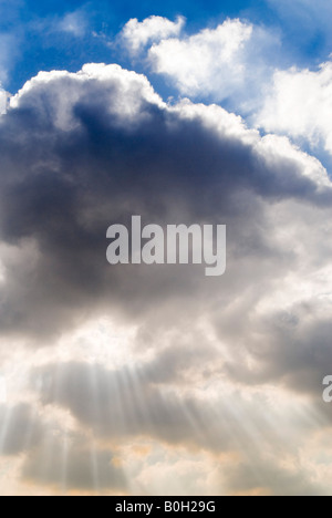 Vertikale Ansicht von einem dramatischen Himmel mit verschiedenen dunklen grauen Cumulus Wolkenformationen und "Finger Gottes" Sonnenstrahlen durchbrechen Stockfoto