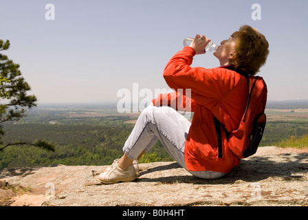 Kaukasische Frau (50-55) ruht und trinkt Mineralwasser bei Petit Jean Staatspark Arkansas USA Stockfoto