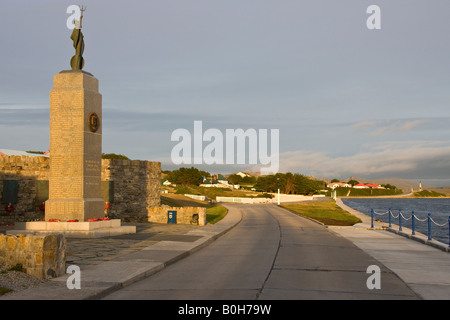 Die Falkland-Inseln War Memorial mit Government House im Hintergrund - Port Stanley auf den Falklandinseln Stockfoto