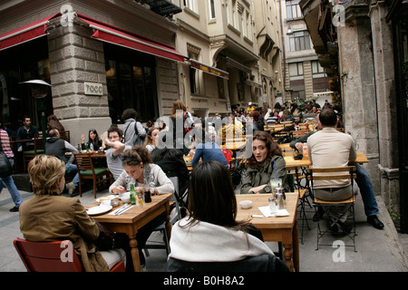 Junge Menschen trinken und Essen gehen in einer Gasse von Tunel, Istanbul Stockfoto