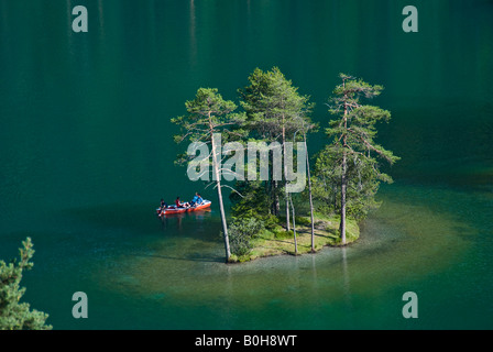 Ruderboot am See Fernsteinsee vorbei an einem kleinen Baum bedeckte Insel, Tirol, Österreich Stockfoto