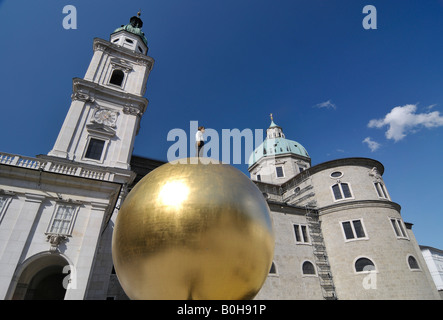 Abbildung eines Mannes stehend auf einer goldenen Kugel vor dem Salzburger Dom, Kapitelplatz Platz im historischen Zentrum von Sal Stockfoto