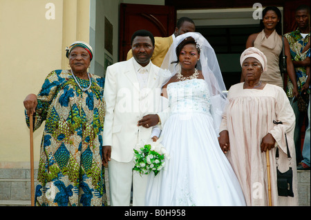 Braut und Bräutigam, Hochzeit paar verlassen Kirche zwischen ihre Schwiegermütter, Douala, Kamerun, Afrika Stockfoto