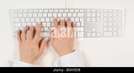 Person auf eine Apple-Tastatur tippen Stockfoto