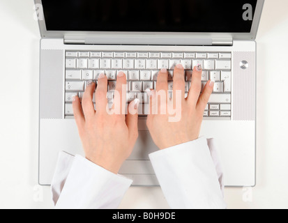 Person auf eine Apple-Tastatur tippen Stockfoto