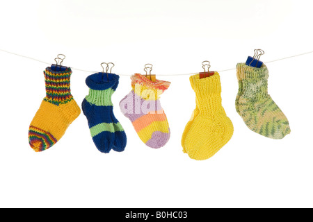 Verschiedene Babysocken von einer Wäscheleine hängen Stockfoto
