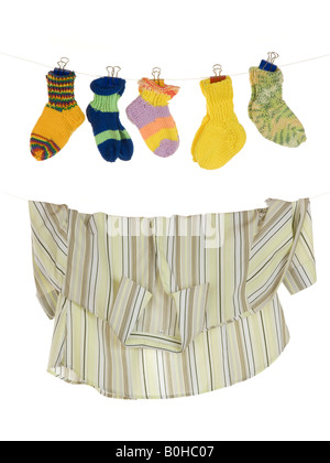 Baby-Socken und Bluse hängen von einer Wäscheleine, symbolisches Bild: Kind oder Karriere, Kinder und Karriere Stockfoto