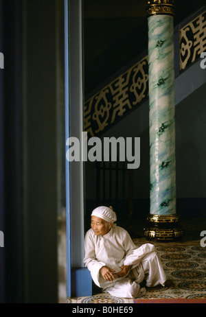 Ein älterer Priester sitzen in der Tür des Cao Dai großen Tempels, Tay Minh, Vietnam. Stockfoto