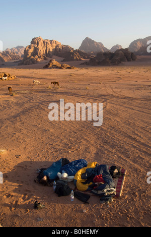 Touristen, die in einem Schlafsack unter freiem Himmel in der Wüste, Wadi Rum, Jordanien, Naher Osten Stockfoto