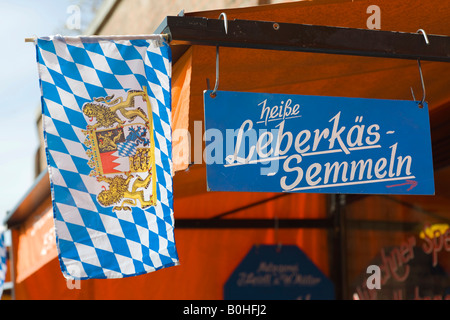 Shop anmelden Werbung "Heisse Leberkaessemmeln" (heißen Hackbraten auf einem Brötchen) neben einem bayerischen Fahne mit Wappen, Metzgerei Stockfoto