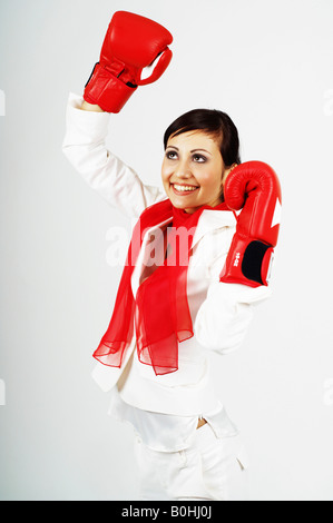 Junge Geschäftsfrau, Manager tragen rote Boxhandschuhe, fröhlich, selbstbewusst Stockfoto
