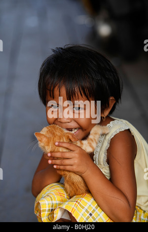 Mädchen hält eine Katze, Borneo, Zentral-Kalimantan, Kalimantan Tengah, Indonesien, Asien Stockfoto