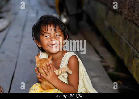 Mädchen hält eine Katze, Kumai, Borneo, Zentral-Kalimantan, Kalimantan Tengah, Indonesien, Asien Stockfoto