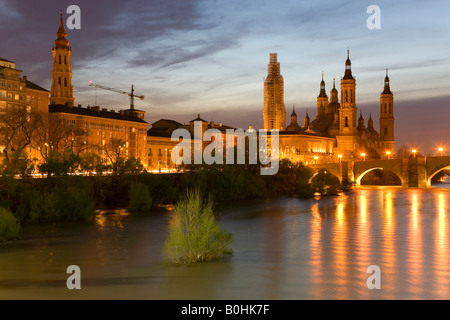 Basilica del Pilar, Basilika unserer lieben Frau von der Säule neben dem Ebro-Fluss und die Brücke Puente de Piedra unter einem Abend s Stockfoto