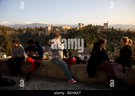 Touristen genießen den Blick auf den maurischen Alhambra-Palast vom Mirador San Nicolas im Stadtteil El Albayzín oder Albaicín Stockfoto